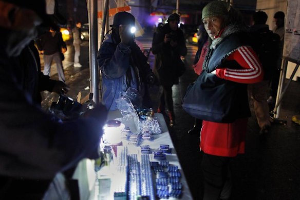 A woman asks the price of a flashlight in the aftermath of Hurricane Sandy in New York