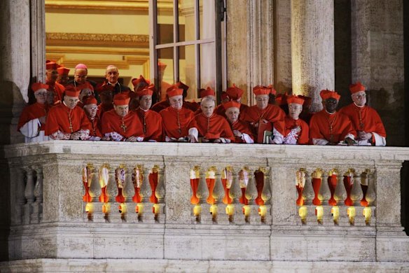 Cardinals watch as Pope Francis speaks to the crowd from the central balcony of St. Peter's Basilica.