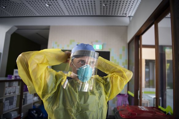 Nurse Jarrod Tunks adjusts his face shield ahead of testing patients.