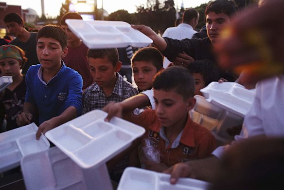 Displaced Syrian Kurdish children queue for food at dinner time in Suruc - the nearest town to the Turkish border with Syria after fleeing their homes over the past two weeks as IS militants closed in on the city of Kobani.