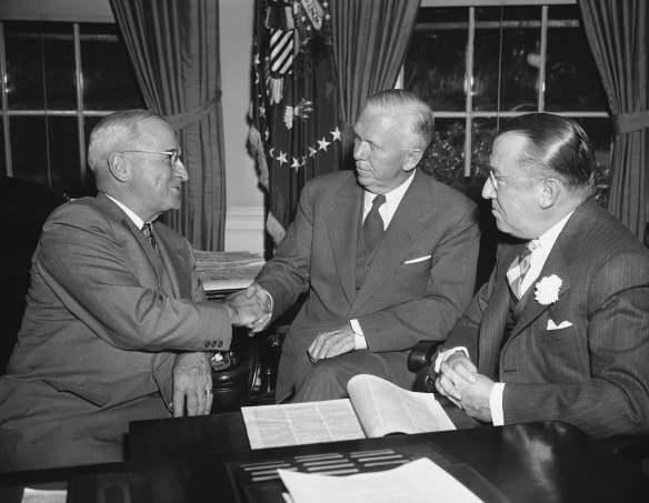 At the White House on October 3, 1949, President Harry Truman, left, congratulates Gen. George Marshall (architect of the Marshall Plan) after the former secretary of state became chairman of the American Red Cross, succeeding Basil O’Connor, right. 