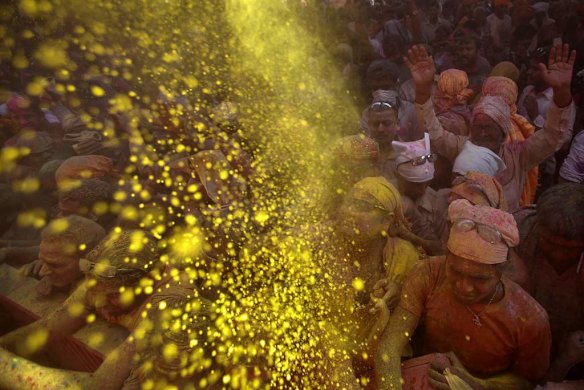 Hindu devotees throw coloured powder at a temple during "Lathmar Holi" at the village of Barsana, India.