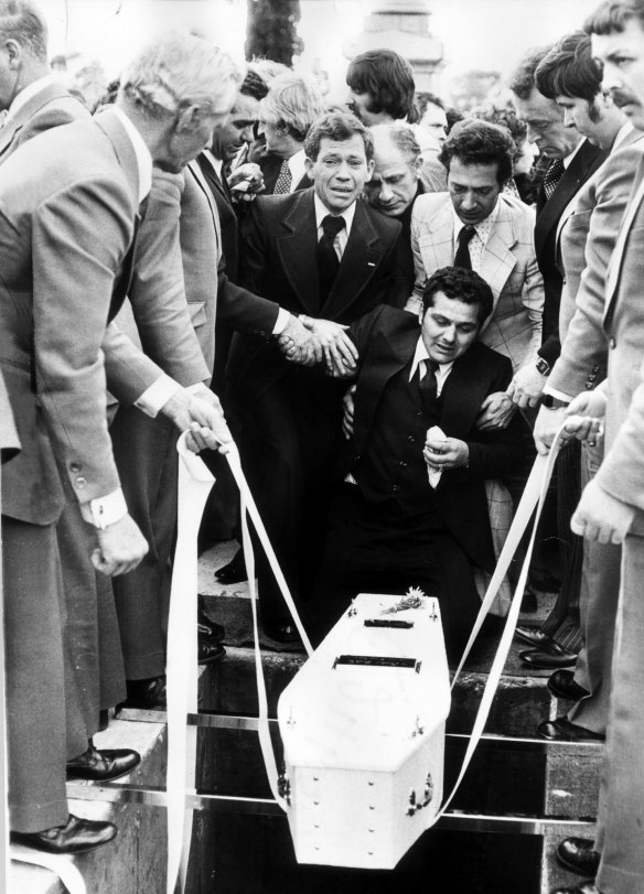 Sam Gulle sobbing as the coffin of his infant child is lowered into a grave.