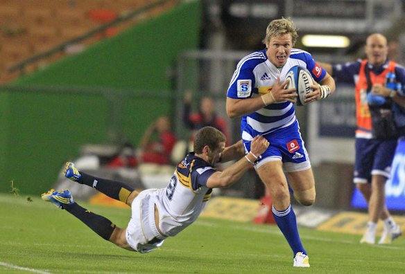 Jean de Villiers of the Stormers runs with the ball as Fotu Auelua of the Brumbies.