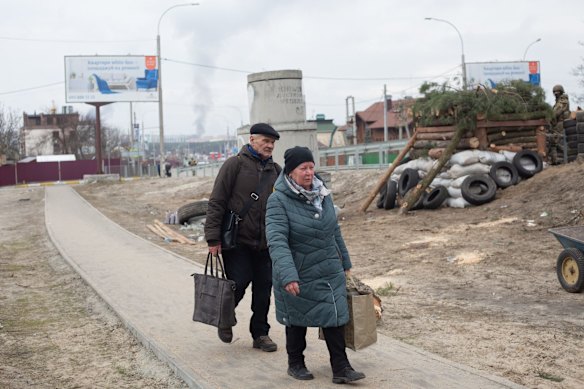 Civilians evacuate from the shelled city of Irpin on Sunday. 