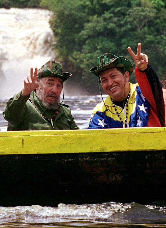In this Aug. 12, 2001 file photo released by Miraflores Press Office, Cuba's President Fidel Castro, left, and Venezuela's President Hugo Chavez wave to a crowd while touring Canaima National Park in eastern Venezuela in a canoe.