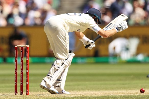 Joe Root of England reacts after being struck by the ball after a delivery from Pat Cummins of Australia.