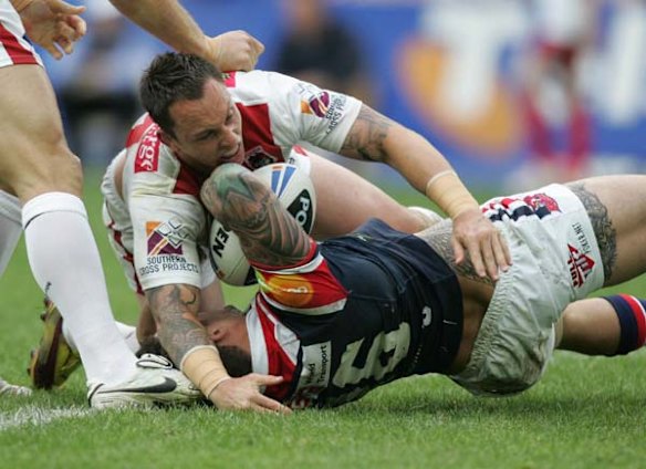 The Roosters Todd Carney is pounded by the Dragons Nathan Fein.