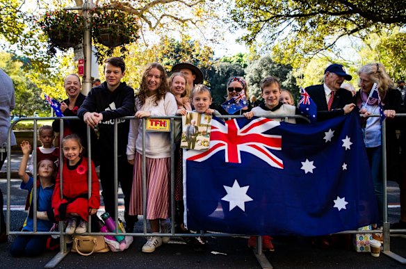 Spectators watch the ANZAC Day march down Elizabeth St, Sydney.