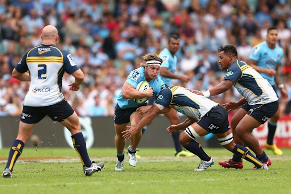 Michael Hooper of the Waratahs is tackled 