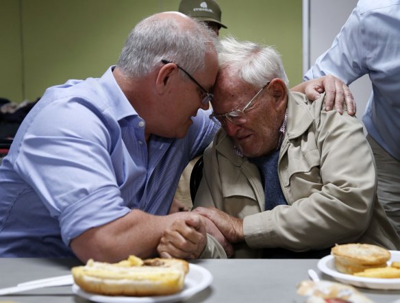 Prime Minister Scott Morrison is seen comforting Owen Whalan during a visit to a Taree evacuation centre on Sunday.