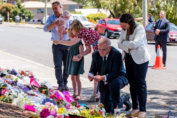 Australian Prime Minister Scott Morrison and his wife Jenny Morrison, alongside Member for Braddon Gavin Pearce (left) and family, read tributes left for the five Hillcrest Primary School students who died on Thursday in a jumping castle incident during end of year celebrations.