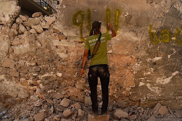 An Iraqi Special Forces soldier spray paints a signal to a wall in West Mosul.