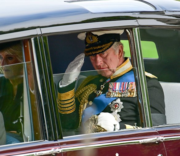 King Charles III and Camilla, Queen Consort are seen in a car as the coffin of Queen Elizabeth II is transferred from the gun carriage to the hearse at Wellington Arch.