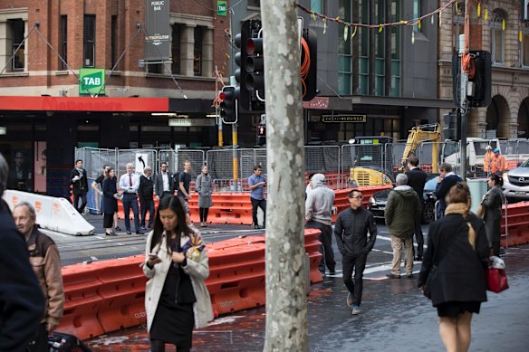 Pedestrians navigate the construction of the light rail at the intersection of Bridge and George Street, Sydney.