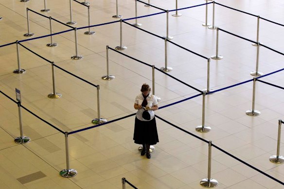 A woman reads her book at the check-in lines of a Johannesburg-bound Qantas flight at Perth international airport October 30, 2011. Photo by Reuters