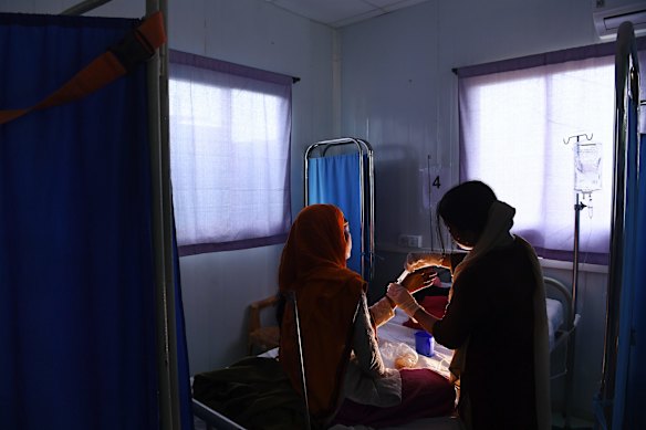 Lalia Begum aged 30 years (left) is attended by a midwife whilst being treated.