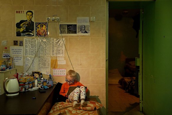 Viktor Baklanov, 3, plays a game on a tablet in the basement at Kharkiv No 4 Emergency Hospital. Viktor was in the car with his mum and brother Volodymyr when they were shot at and their mother was killed. 