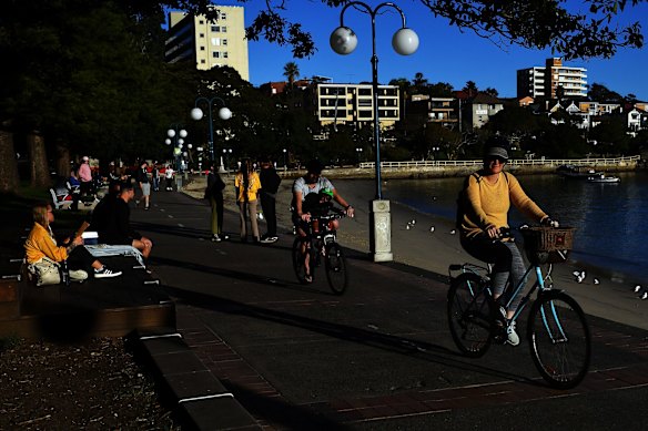 People exercise near Manly Wharf on Sunday under lockdown conditions.  Across Sydney on Sunday, crowds hit the parks, beaches and walking trails. 