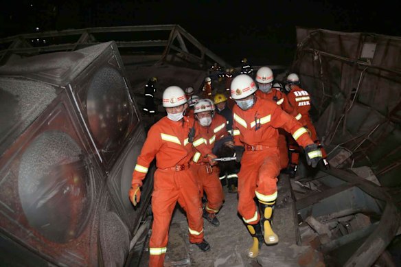 Rescuers evacuate an injured person from the rubble of a collapsed hotel building in Quanzhou city. 