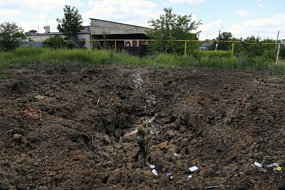 Commander of a Ukrainian armed forces unit Simon Salatenko stands in the crater of an air strike amongst residential homes in the town of Krasnohorivka. This area has been a focal point in the eight year war between Ukraine and Russian-backed separatists. Krasnohorivka, Ukraine. 