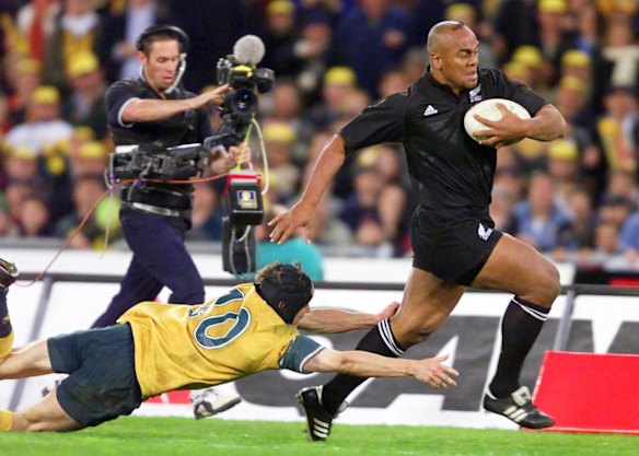 Might and power: Jonah Lomu evades Stephen Larkham during the memorable 39-35 win over the Wallabies at Stadium Australia in July, 2000.