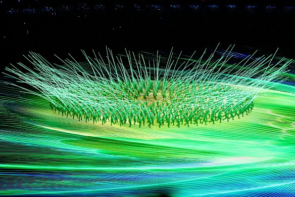 Performers create a flower display with LED lights.