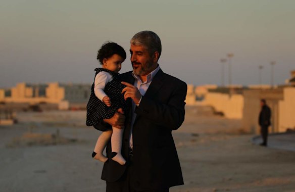 Khalid Mishal (center) holds his one year old granddaughter Sara (left), as he goes for a short walk in the suburban streets of Doha, Qatar.