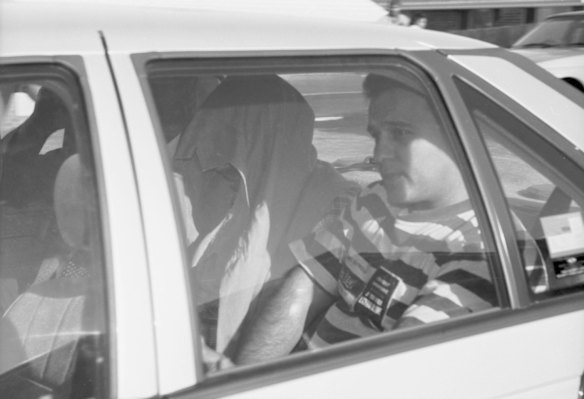 Detective Senior Sergeant Steve Leach, left, and other detectives take then prime suspect, the backpacker killer Ivan Milat into custody after raiding his home in Cinnabar Street, Eagle Vale. Taken on 22 May 1994.