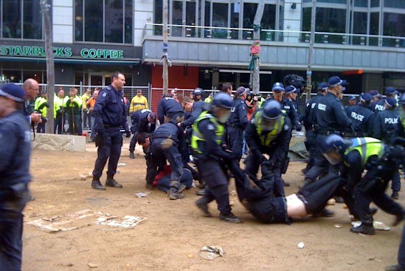 Police drag protesters by the arms and legs in City Square.