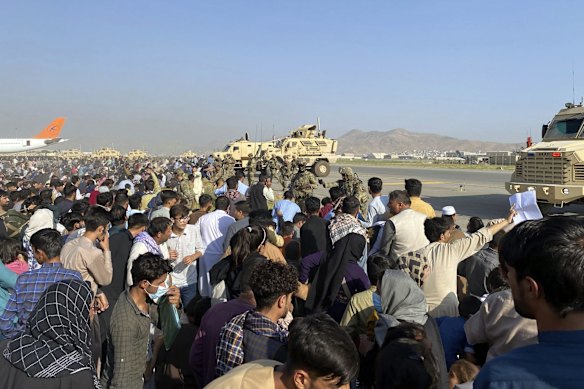 U.S soldiers stand guard along a perimeter at the international airport in Kabul, Afghanistan. On Monday, the U.S. military and officials focus was on Kabul's airport, where thousands of Afghans trapped by the sudden Taliban takeover rushed the tarmac and clung to U.S. military planes deployed to fly out staffers of the U.S. Embassy. 
