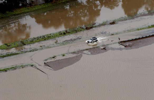 Hunter Valley flooding, showing a vehicle driving through a flooded road near Paterson.