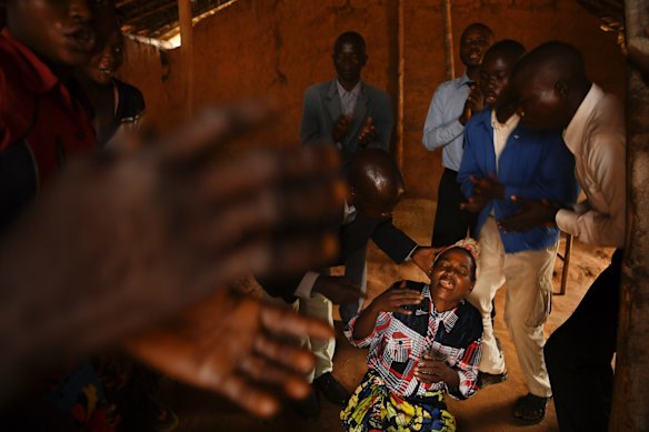 A religious group perform an exorcism on a woman in small church in Tshimbulu village. In the DRC more than 70 percent of the population attend religious services weekly. Of those approximately 90% follow some form of Christianity. Exorcisms occur frequently to rid the person of spirits or to rid them of disease or cure their problems. 