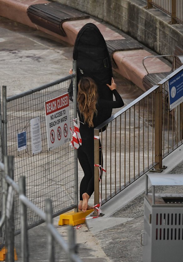 Surfers and swimmers negotiate barriers at Tamarama Beach.