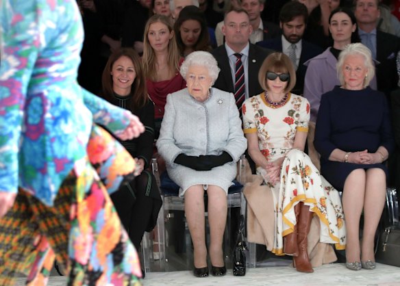 Britain's Queen Elizabeth, second left, sits next to fashion editor Anna Wintour, second right, and Caroline Rush, chief executive of the British Fashion Council (BFC), left, as they view Richard Quinn's runway show before presenting him with the inaugural Queen Elizabeth II Award for British Design, as she visits London Fashion Week.