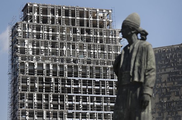 A statue representing the Lebanese expatriate is seen in front of a building that was damaged by an explosion that hit the seaport of Beirut, Lebanon.
