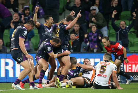 Where there's a will: Melbourne celebrate as Will Chambers scores the match-winning try against the Tigers.
