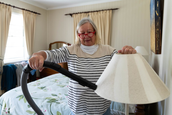 Margot White vacuums coal dust from a bedside lamp that she says has collected there for the past month. 
