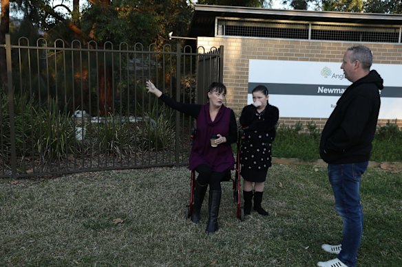 Liz Lane with her daughter Samantha and Anthony Bowe gather outside Anglicare Newmarch House. Anglicare has appointed an independent adviser to oversee its management of the deadly coronavirus outbreak at Newmarch House nursing home in western Sydney, where 16 elderly residents have died and 69 people have been infected – including another three staff members picked up by screening on Wednesday.
