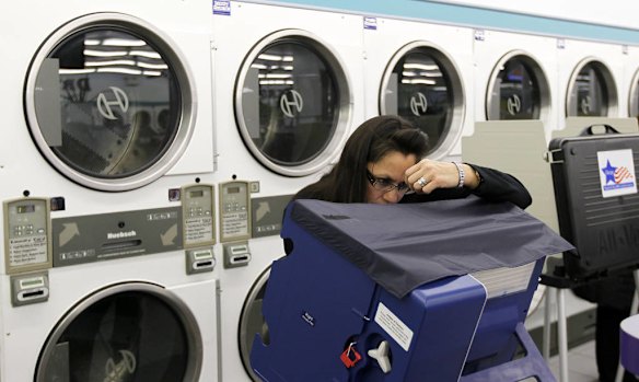 Leslie Fabian concentrates as she votes electronically inside at the 24-hour Su Nueva Laundromat in Chicago's 13th Ward in Chicago.