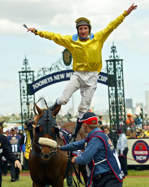 Damien Oliver jumps off Media Puzzle after winning the 2002 Melbourne Cup.
