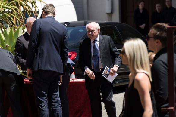 Former prime minister John Howard holding a funeral booklet of John Fordham at St Francis of Assisi's Catholic Church on Friday.