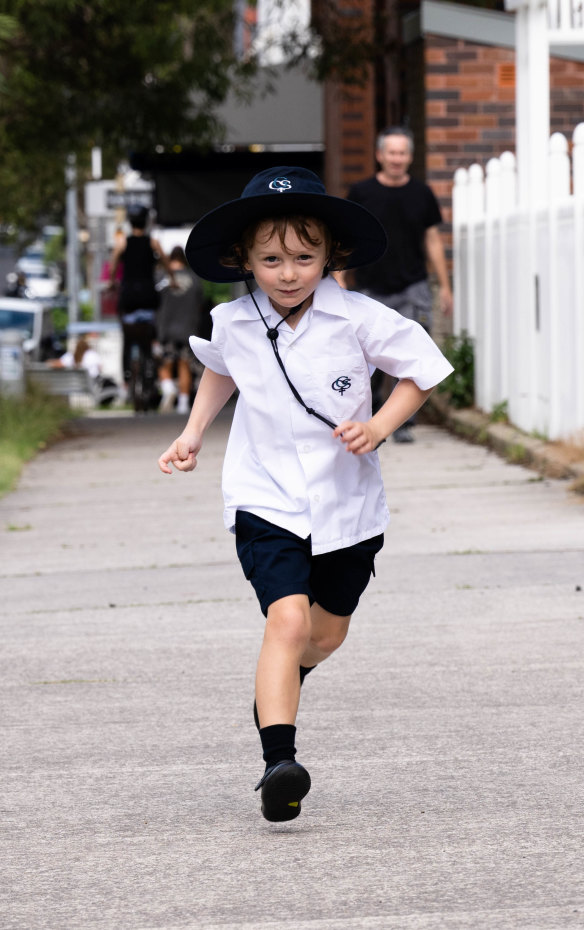 Michael Quinn, with dad Kevin trailing behind, runs to Galilee Catholic Primary School in Bondi Beach.