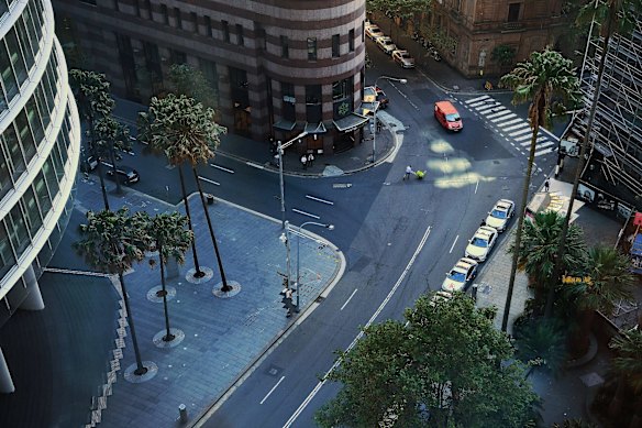 An aerial view of a near-empty Bent street in the CBD of Sydney. March 18, 2020.

“I was waiting to photograph a businessman in the first week of restrictions and looked down from this office building onto the deserted streets below, when a man pushing a trolley slowly made his way across the normally very busy intersection in the CBD. I’m used to covering zones of conflict and their aftermath, so deserted streets, panic buying, and police checkpoints are not unusual for me; but to see this in your own country is surreal.” – Kate Geraghty, who has worked as a photographer for the Sydney Morning Herald since moving to Sydney in 2002.
