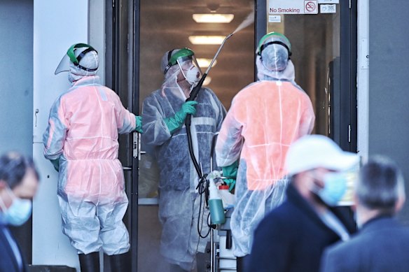 Hazmat suited cleaners disinfecting the lower floor of a building in Blacktown which has been quarantined. A Blacktown social housing complex has been forced into lockdown after six residents across three households tested positive to COVID-19. The unit block, owned by community housing provider Evolve Housing, is under police guard and all residents have been tested.