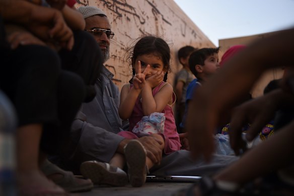 Aisha Mohammed (2nd from left) making the peace sign sits with her family on a truck after they arrived safely at a screening point after being rescued by Iraqi forces.
