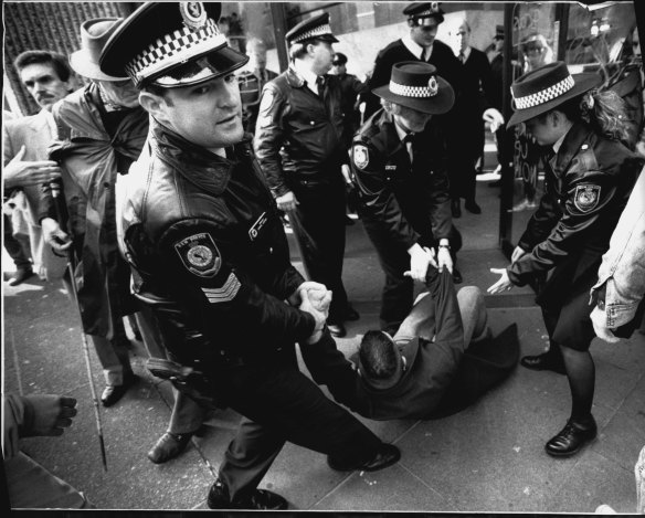 Police arrest an AIDS activist at a demonstration outside the US Consulate.