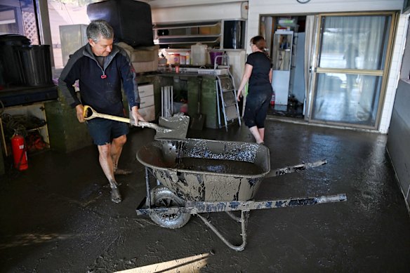 Russell Strickland and Tracey Flood clearing mud from their cabin at the Leetsvale Caravan Park on the Hawkesbury River.