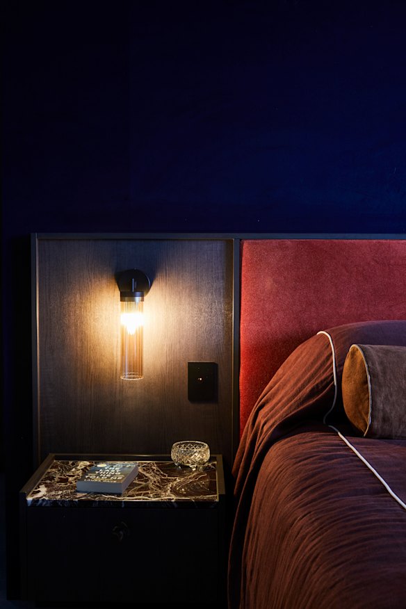 Velvet wallpaper, a velvet bedhead and rust-coloured bedlinen bring colour and
texture to the main bedroom. The bedside tabletop is Rosso Levanto marble.