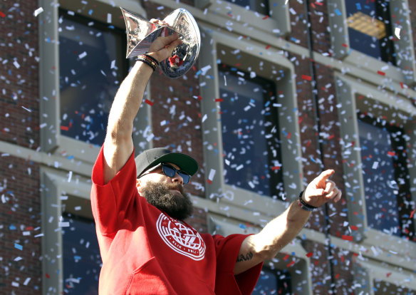 Julian Edelman holds up the Patriots' trophy during a victory parade through Boston.